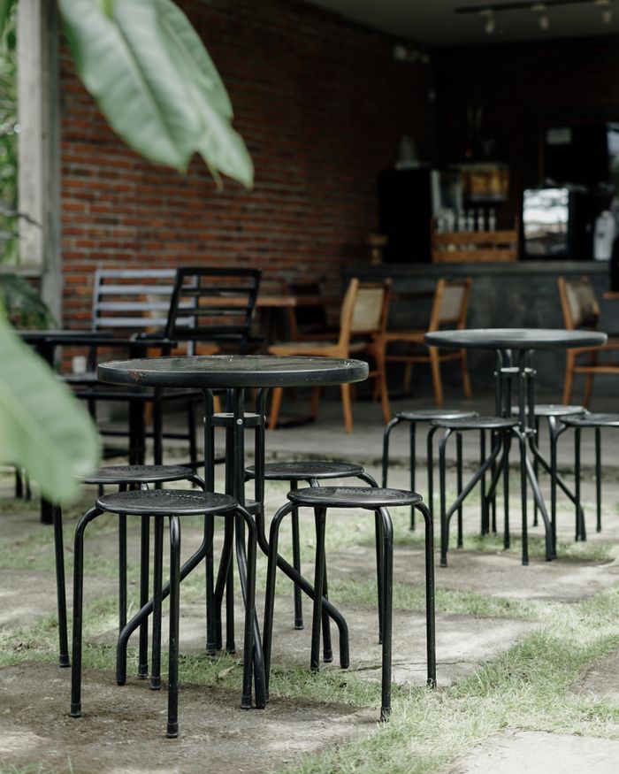 Charming outdoor bistro with metal tables and chairs, perfect for a serene café experience.